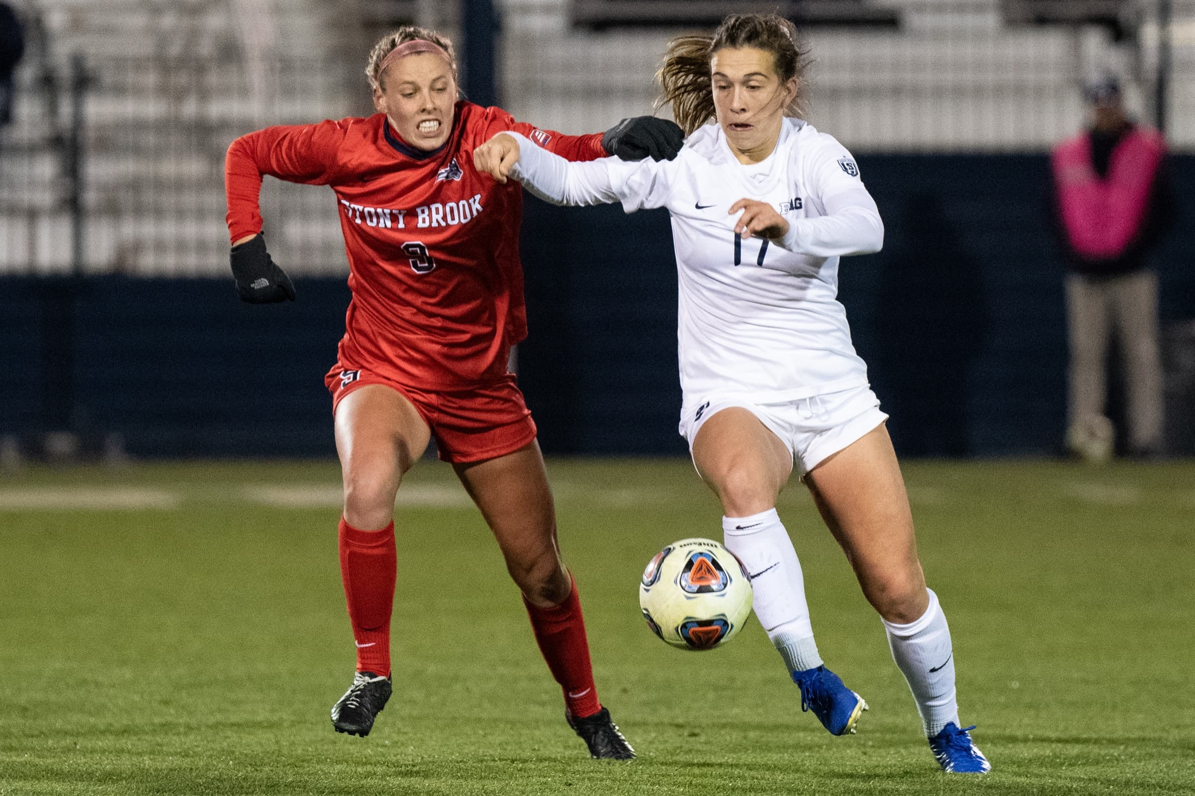 A Stony Brook and a Penn State women's player racing for the ball
