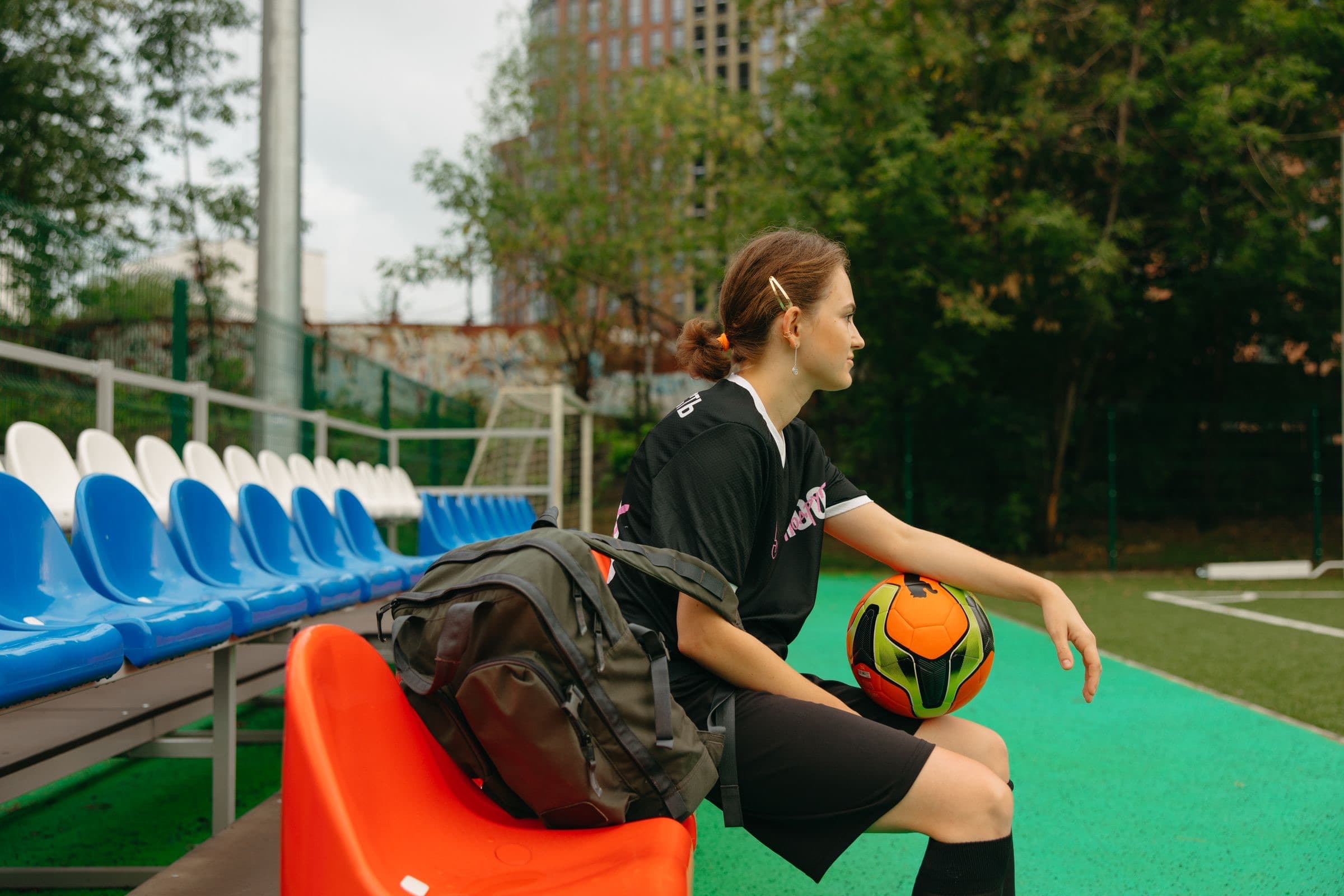 A player sitting on the bench with the ball in her lap