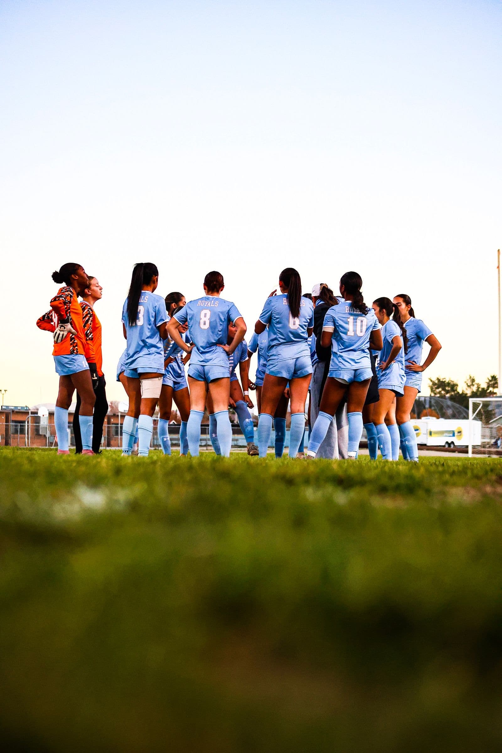A high school girls' team in a huddle during a game