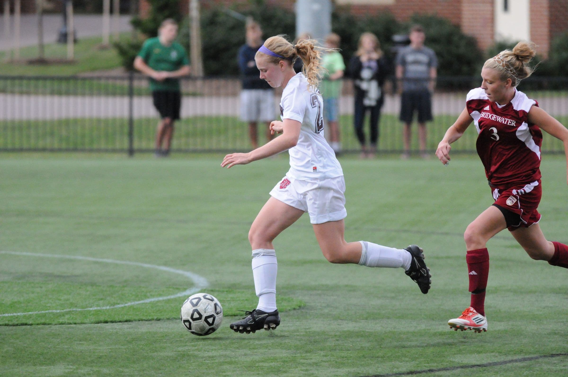 A Roanoke and a Bridgewater women's player chasing the ball