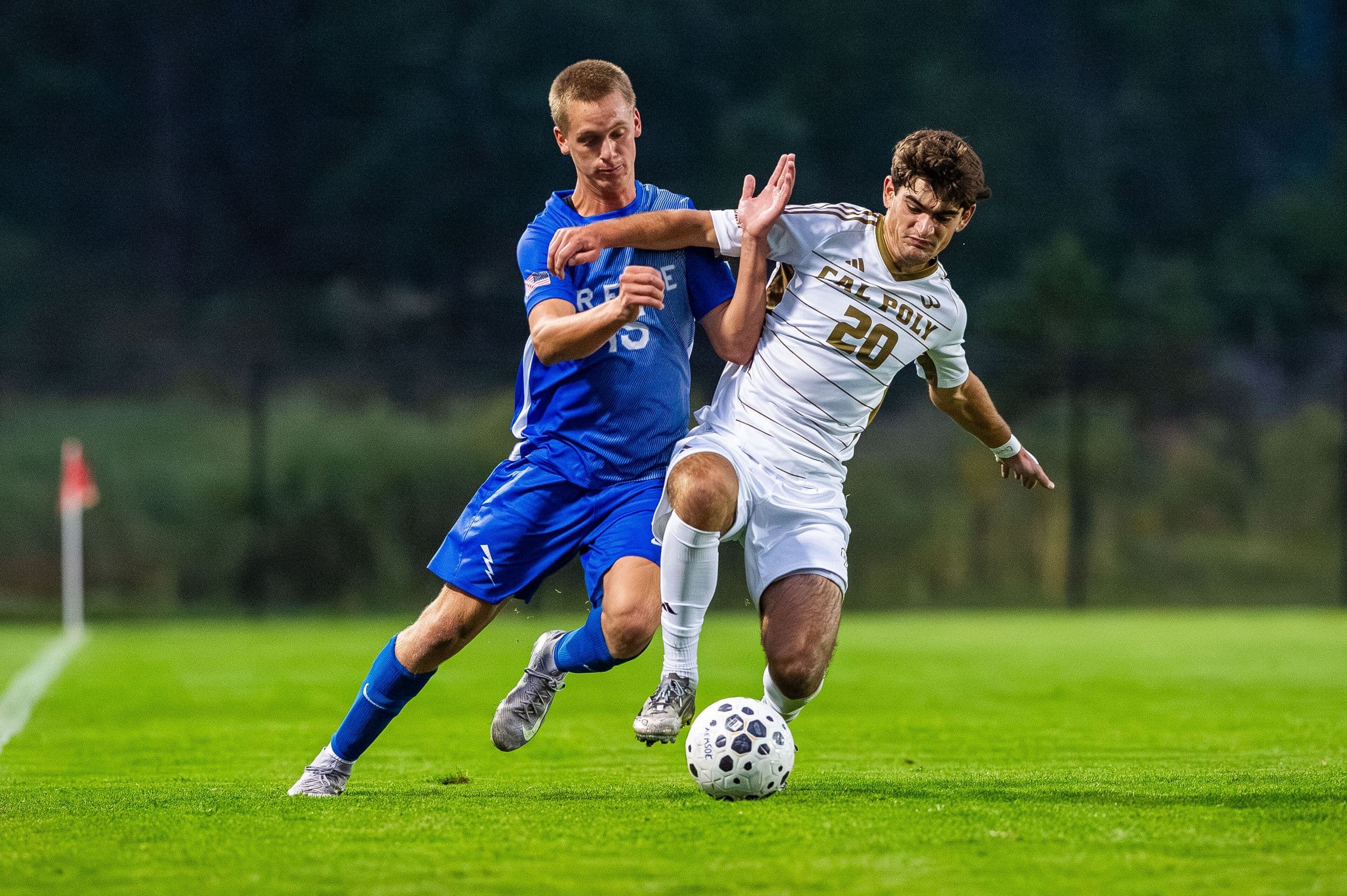 An Air Force and a Cal Poly men's player battling for the ball