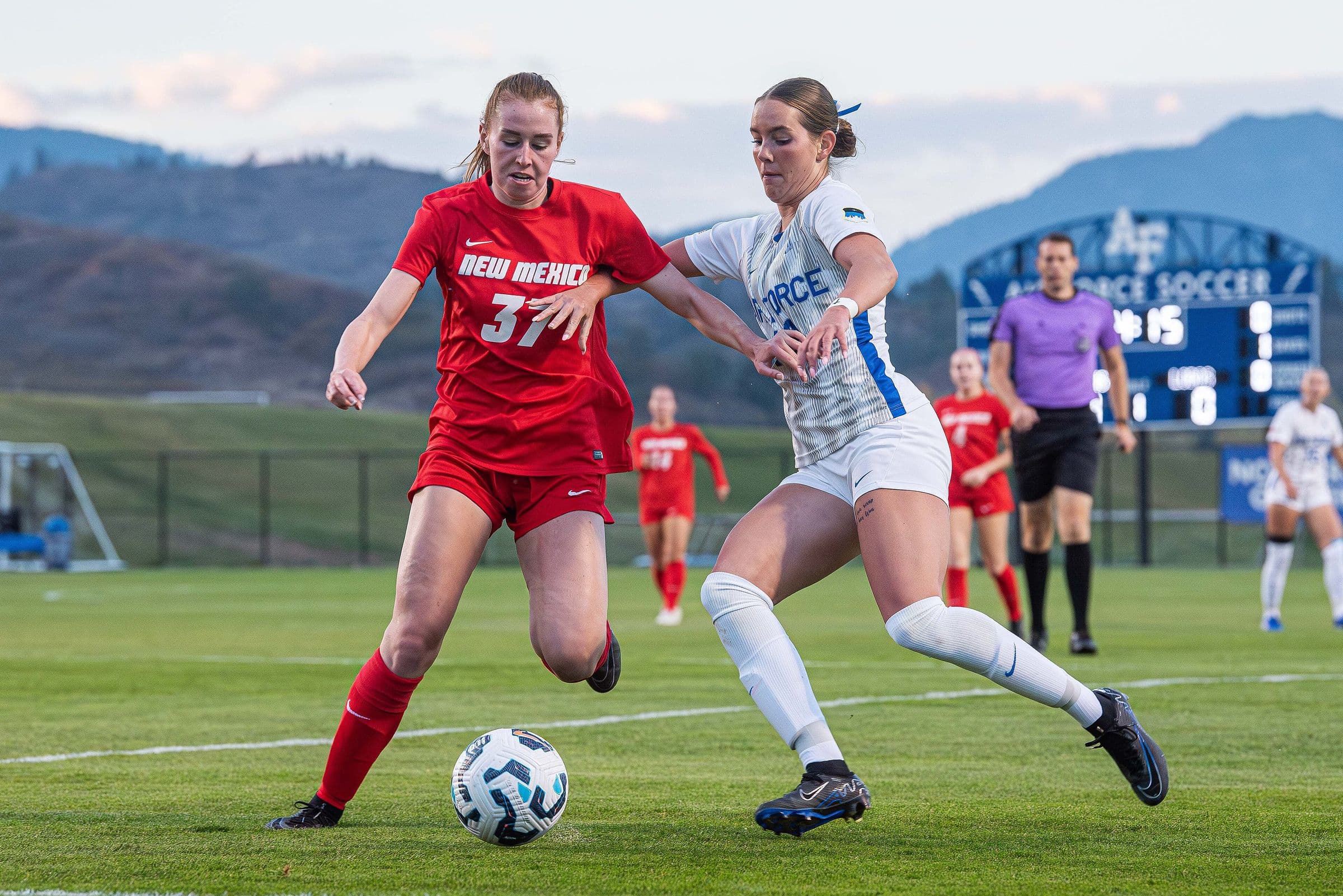 An Air Force and a New Mexico women's player racing for the ball